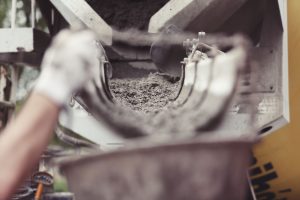 Wet concrete being poured at a construction site foundation