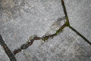 A single defined crack running across a grey concrete slab